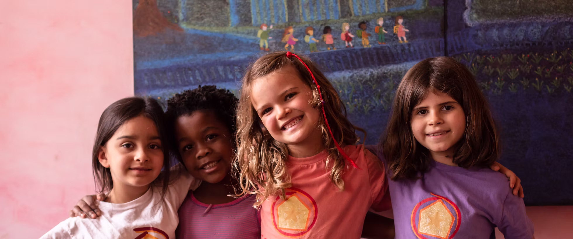 Crianças da Casa Áurea abraçadas, com camisetas da escola